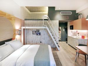 a bedroom with a large bed and a staircase at Second Nature Southampton in Southampton