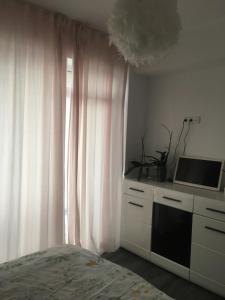 1 dormitorio con 1 cama y ventana con microondas en True Modern - apartment, en Valea Lupului