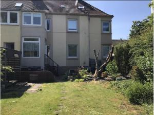 a house with a fallen tree in the yard at Dat Sottje Huus in Wilhelmshaven