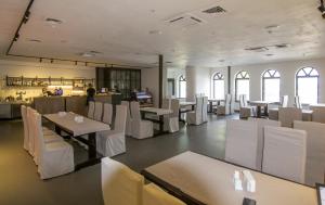 a restaurant with white chairs and tables and a bar at Knyazha Hora Hotel in Kaniv