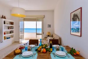 a dining room with a table with a view of the ocean at Sunrise over the sea in Noto Marina