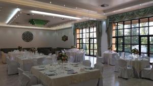 a banquet hall with white tables and chairs and windows at Palahotel Vallenoce in Decollatura