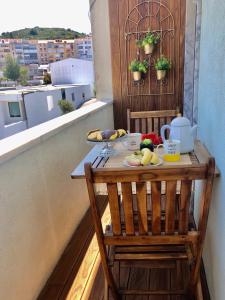 a table on a balcony with a tray of food at Apartamento T1 no centro TÊ-U in Torres Vedras