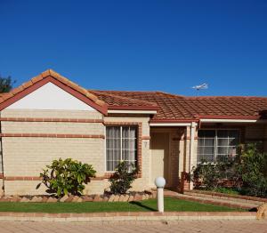 a brick house with a red roof at Beachside Retreat 2 in Rockingham