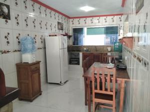 uma cozinha com um frigorífico, uma mesa e cadeiras em Casa Piscina Azul em Paraty