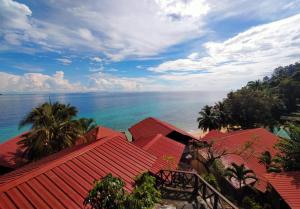 einen Blick auf das Meer von einem Resort mit roten Dächern in der Unterkunft Panuba Inn Resort in Tioman Island