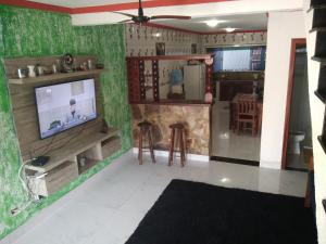 een woonkamer met een tv en een keuken bij Casa Piscina Azul in Paraty