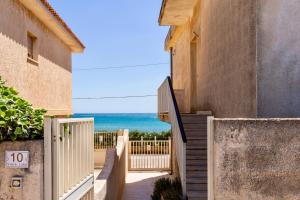 a stairway leading to the beach from a house at Sunrise over the sea in Noto Marina