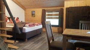 a bedroom with a bed and a window and a table at Chalet bei der Arve in Grindelwald