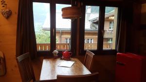 a table in a room with a large window at Chalet bei der Arve in Grindelwald