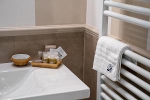uma casa de banho com um lavatório branco e uma toalha em Blu Hotel em Lavagna