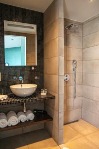 une salle de bain avec un lavabo et une douche dans l'établissement De Pier Suites, à Scheveningen