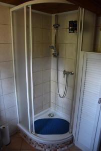 a bathroom with a shower with a blue tub at Gemütliches Blockhaus, Waldblick, Nähe BER/SXF in Berlin