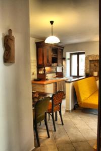 una cucina con tavolo, sedie e divano giallo di Apartment with soul a Mošćenička Draga