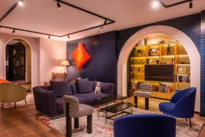 uma sala de estar com um sofá roxo e cadeiras em Golden Tulip Opera de Noailles em Paris
