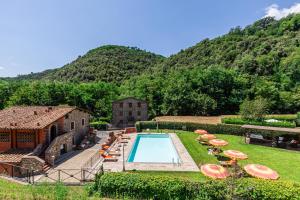 an estate with a swimming pool in front of a mountain at Casa Di Meo in Monsagrati