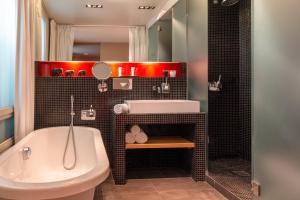 a bathroom with a sink, toilet and bathtub at Golden Tulip Opera de Noailles in Paris