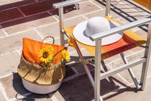 una silla con sombrero y una mesa con girasol en Casa Di Meo, en Monsagrati