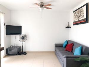 uma sala de estar com um sofá e uma ventoinha de tecto em Modern Pool Side 3 Bedroom House, Puerto Vallarta em Puerto Vallarta