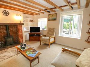 a living room with a couch and a fireplace at Primrose Cottage in Wells next the Sea