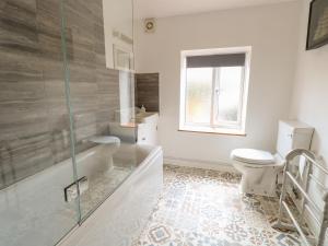 a bathroom with a toilet and a glass shower at Primrose Cottage in Wells next the Sea +26 photos