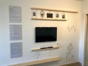 Ein Flachbildfernseher hängt an einer weißen Wand in der Unterkunft Apartamento T1 no centro TÊ-U in Torres Vedras
