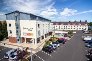een parkeerplaats met auto's geparkeerd voor een gebouw bij Belmore Court & Motel in Enniskillen