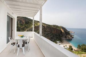 a white balcony with a table and a view of the ocean at Bella vista Suites in Karpathos