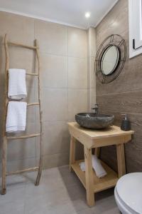 ein Bad mit einem Waschbecken und einem Spiegel in der Unterkunft Bella vista Suites in Karpathos