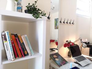 a book shelf with books and a laptop on a desk at Park Villa Boutique Hostel in London