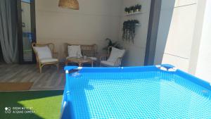 una piscina azul en una sala de estar con sillas en LA POSADA DE MYA, en Villarejo de Salvanés
