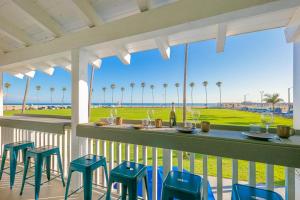 une terrasse couverte avec un bar et des chaises offrant une vue sur la plage. dans l'établissement Oceanfront Balboa Boardwalk Units I, II, & III, à Newport Beach