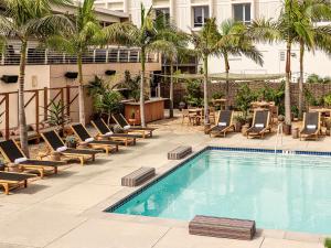 a swimming pool with lounge chairs and a hotel at Hotel June West LA, a Member of Design Hotels in Los Angeles