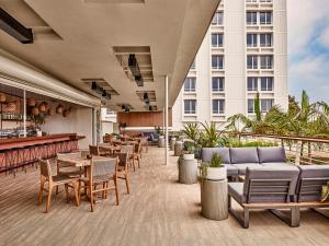 a hotel patio with tables and chairs and a bar at Hotel June West LA, a Member of Design Hotels in Los Angeles