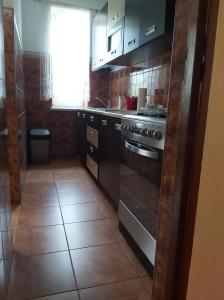 a kitchen with a stove and a tile floor at Apartament Berezka 667-108-706 in Polańczyk
