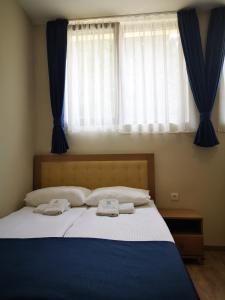 a bedroom with a large bed with two towels on it at Apartments&Camping ZIP in Kremna