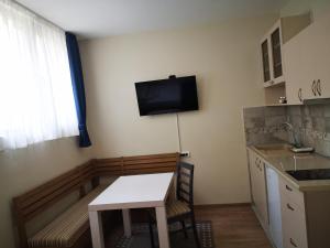 a kitchen with a table and a tv on the wall at Apartments&Camping ZIP in Kremna