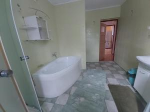 a bathroom with a white tub and a sink at Apartament Berezka 667-108-706 in Polańczyk +10 photos