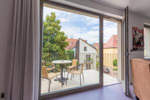 a sliding glass door leading to a balcony with a table and chairs at Ferienwohnungen Noah zu Erfurt in Erfurt