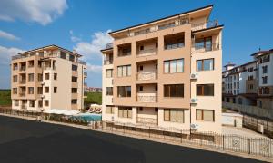 an apartment building with a pool in front of it at Stanny Court ApartHotel in Nesebar
