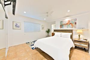 1 dormitorio con cama blanca y ventana en Newport Pacific I & II en Newport Beach