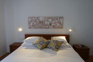 ein Bett mit zwei Kissen und einem Bild an der Wand in der Unterkunft Room Novakovic in Biograd na Moru