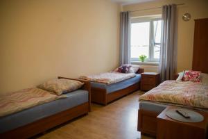 a room with three beds and a window at Pod Kogucikiem in Krzyżanowice
