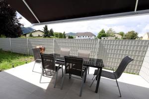 una mesa de comedor negra y sillas en un patio en Exklusive FW mit 3 SZ und großer Terrasse, en Gratkorn