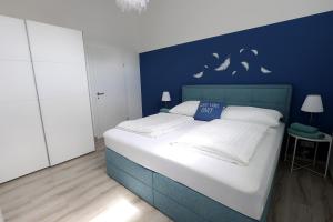 a bedroom with a large bed with a blue wall at Exklusive FW mit 3 SZ und großer Terrasse in Gratkorn