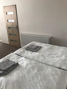 Una cama blanca con dos toallas encima. en Apartmánové ubytovanie v priemyselnej zóne, en Vranov nad Topľou