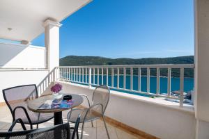 einen Balkon mit einem Tisch, Stühlen und Meerblick in der Unterkunft Hotel Luna in Neum