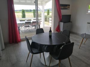 a black table with chairs and a bottle of wine at La Rivière in Pujols Gironde