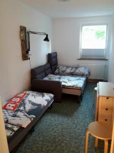 Cette chambre dispose d'un canapé, d'un lit et d'une fenêtre. dans l'établissement Birkenhof Ashram Shanti Zimmer, à Zittau
