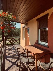 a wooden table and chairs on a patio with a window at Ośrodek Wczasowy Belona - BON TURYSTYCZNY in Niechorze